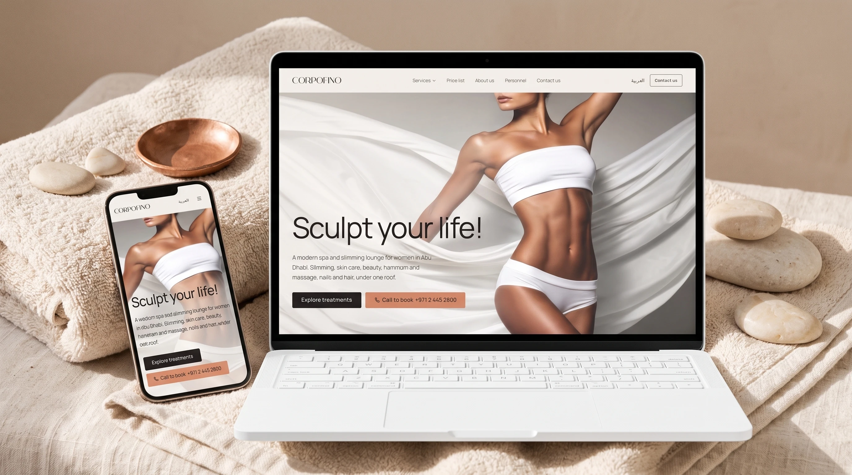 The Corpofino website on a laptop and a phone, on a folded linen spa towel with pale stones and a copper dish